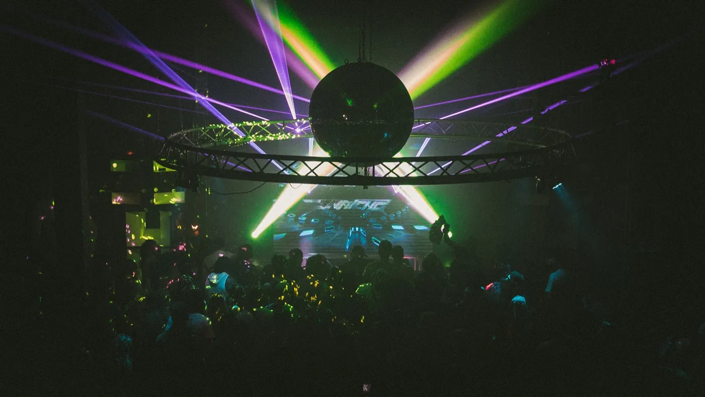 Underground Garden dance floor under lasers and a disco ball at a warehouse night event