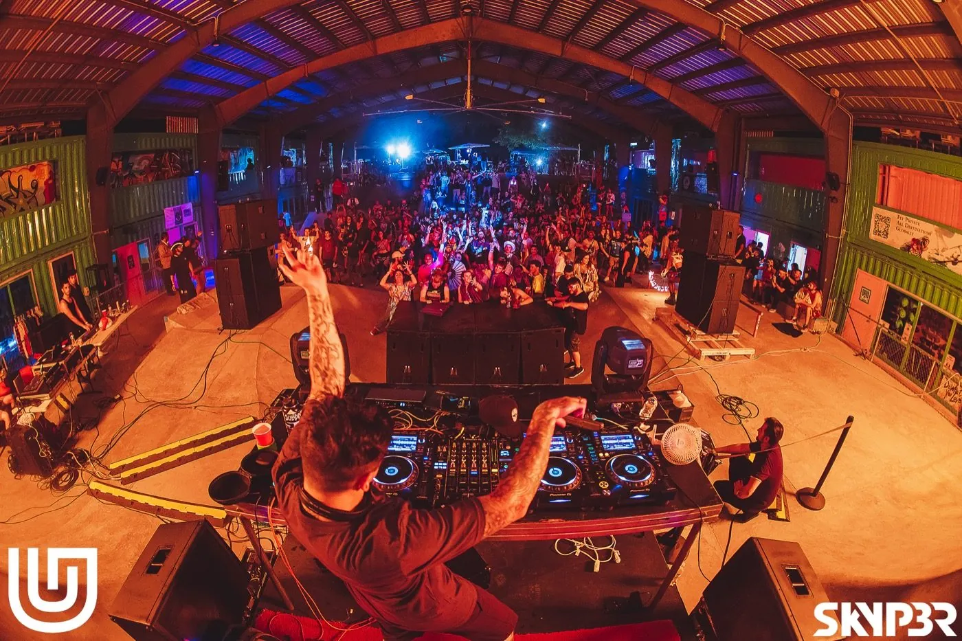 Underground Garden warehouse night event — DJ set overlooking a packed crowd
